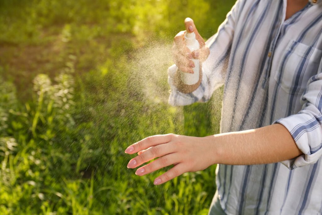 Applying bug repellant, summer skin care